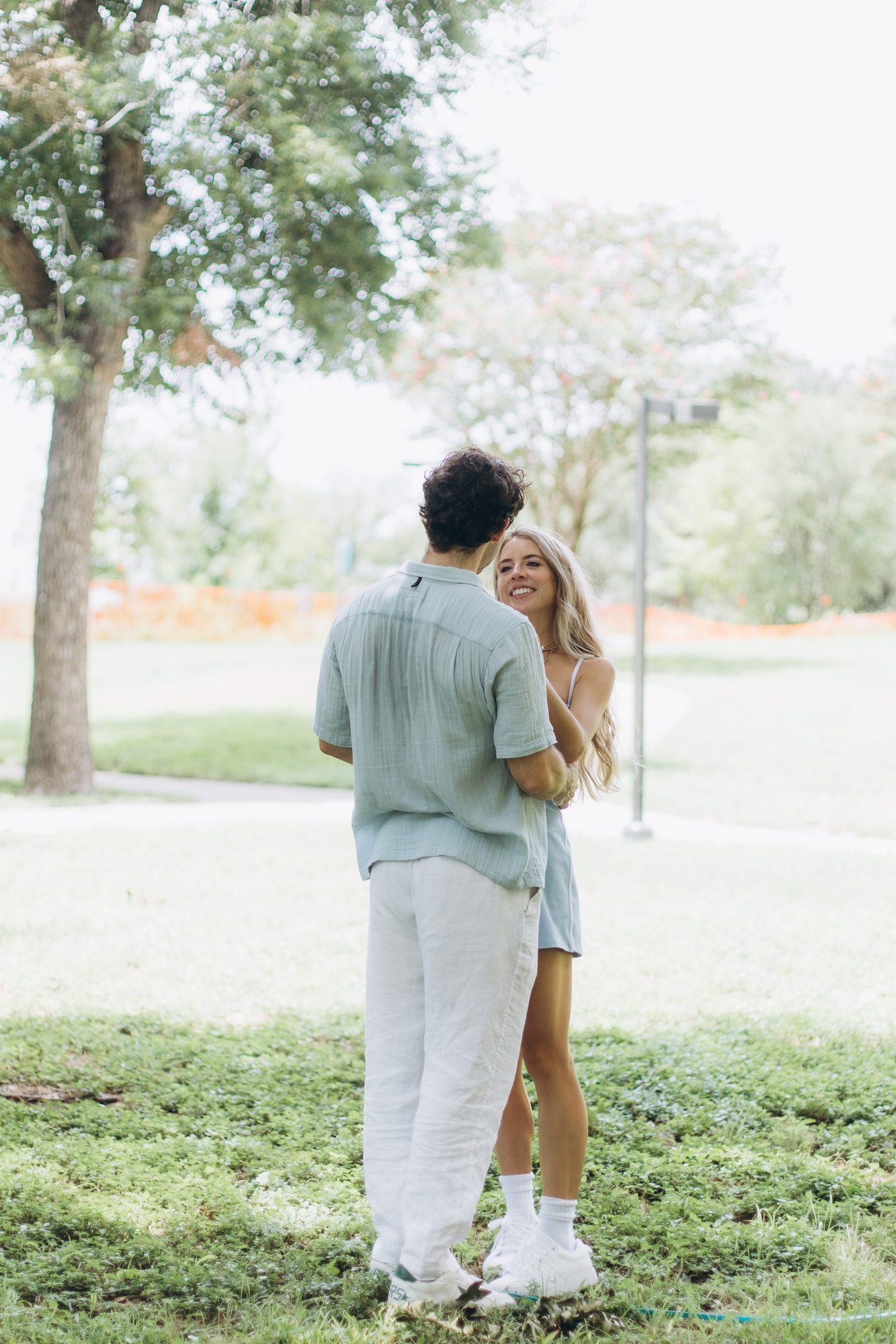 Mary smiling up at Hunter as they stand together under the trees