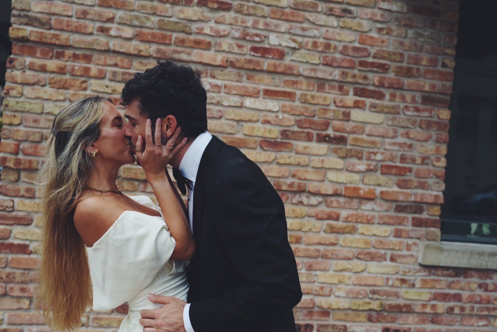 Mary holding Hunter's face as they kiss in their evening clothes