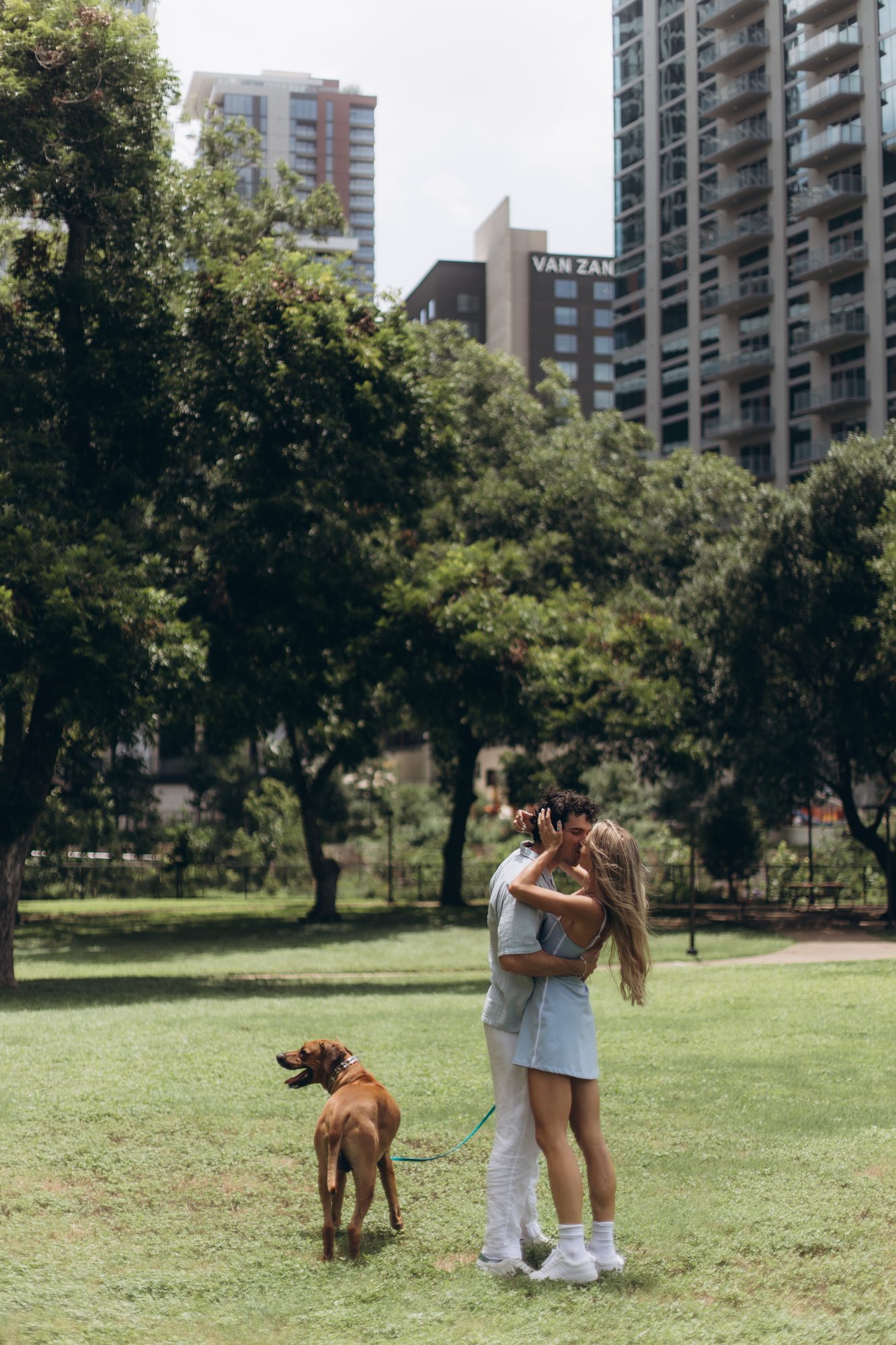 Hunter and Mary kissing in the park while Obi waits beside them