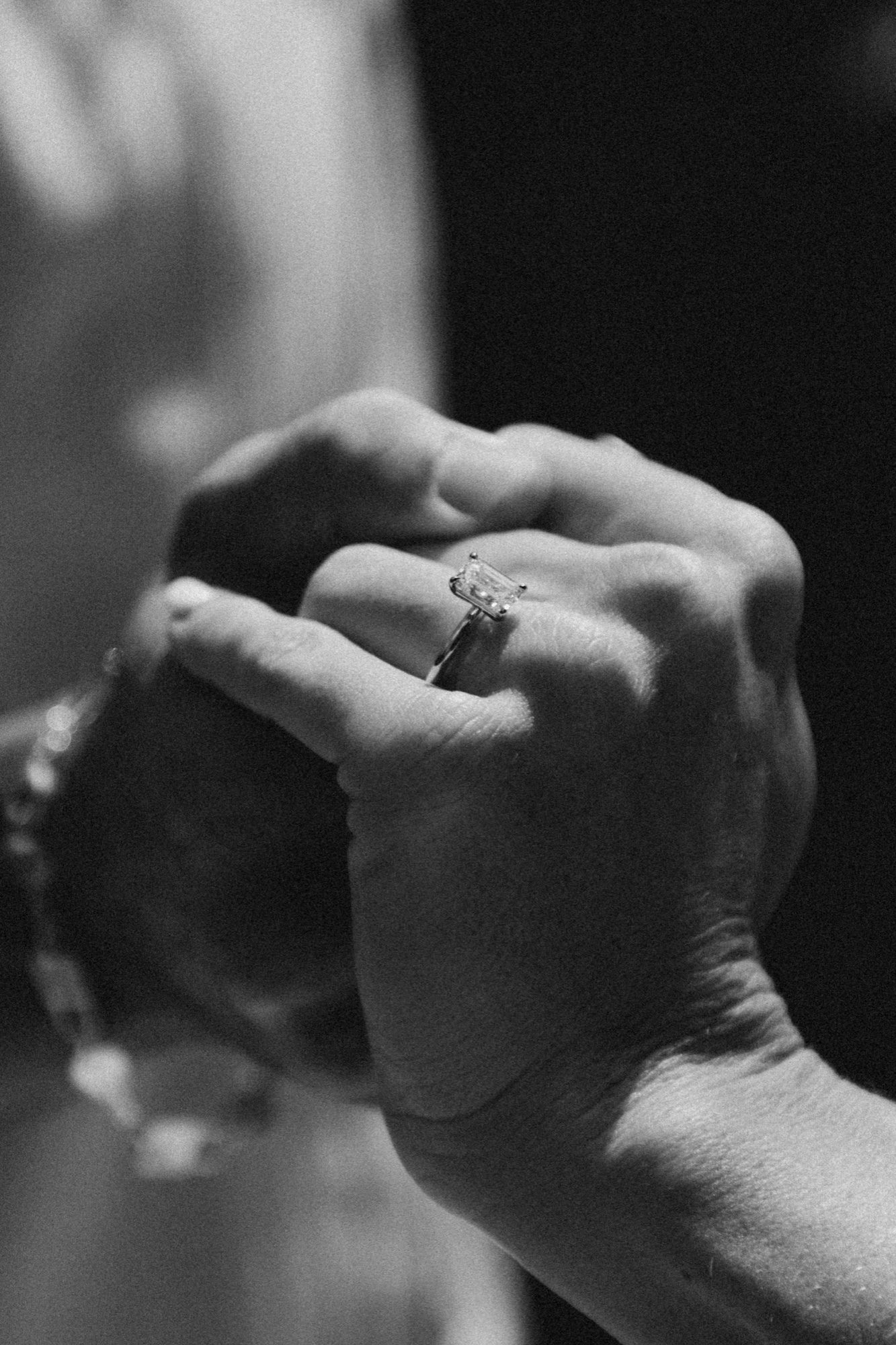A close-up of Mary's engagement ring as they hold hands